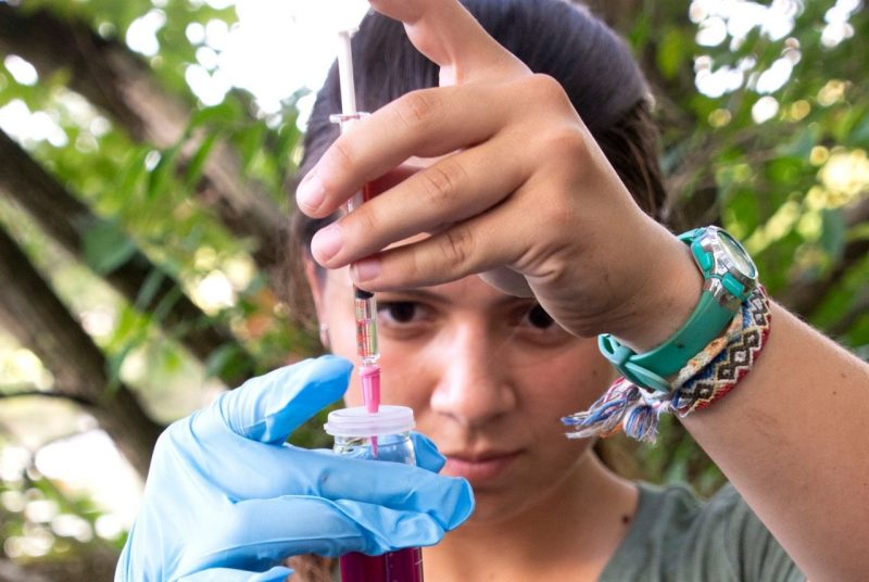 girl at Duck Pond testing water in tube